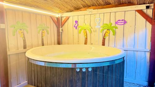 a bathroom with a tub with palm trees on the wall at Hubertówka Czapiewice in Czapiewice
