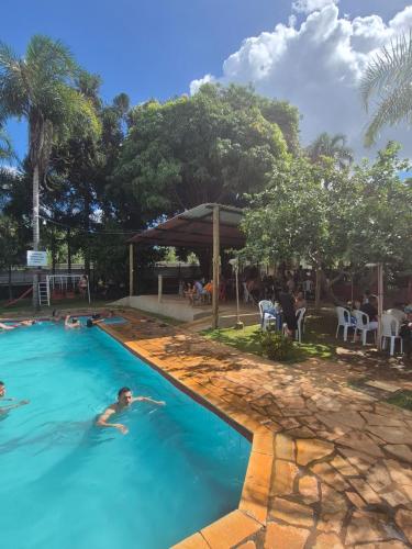 two people swimming in a pool at a resort at Chacara Maua Eventos in Planaltina