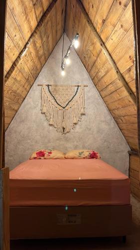 a bedroom with a bed in a attic at Camping Proibido Não Viver in Cruz