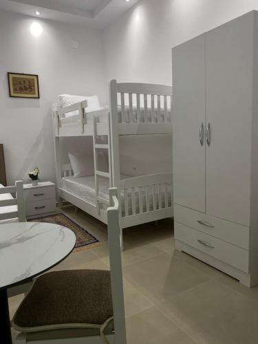 a white room with a bunk bed and a white cabinet at Casa de Flori in Përmet