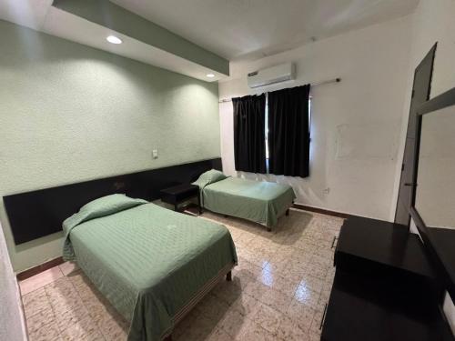 a hotel room with two beds and a window at Hotel y Restaurante Ritz de Tabasco in Villahermosa