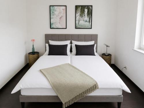 a bedroom with a large white bed with two pillows at Cosima in Hohenroth