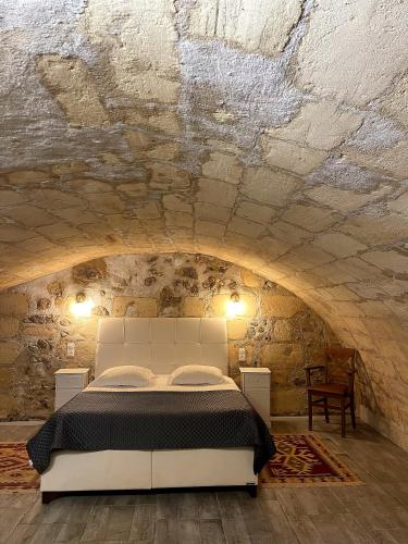a bedroom with a white bed in a stone wall at Au 47 in Bordeaux