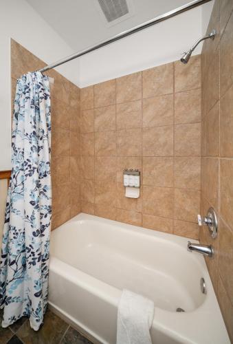 a bathroom with a tub and a shower curtain at Morning Star Lodge - Hosted by Linda in Kellogg