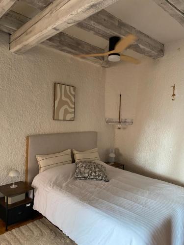 a bedroom with a white bed with a ceiling fan at Le Cocon du lion in Belfort