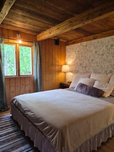 a bedroom with a large bed in a room at Scandinavian forest retreat in Ljungbyhed