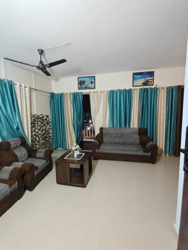 a living room with two couches and a coffee table at Aura Vista in Bhopal