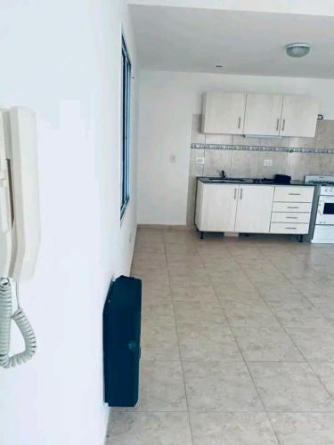 an empty kitchen with a blue suitcase in a room at Los Bajitos in Maipú