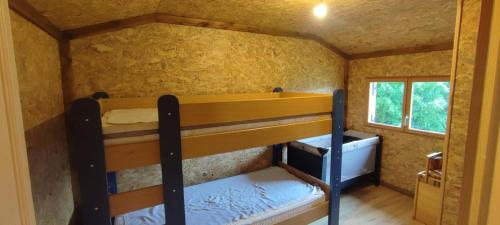 a small room with two bunk beds in it at Wooden chalet with splendid view in Fresse-sur-Moselle