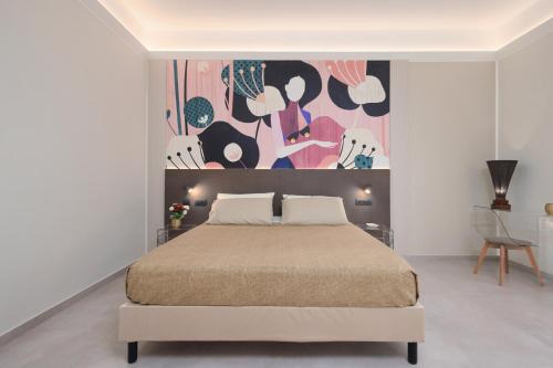 a bedroom with a bed and a painting on the wall at BellDuomo Suite Messina in Messina