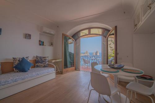a living room with a couch and a table at Casa vista Faraglioni Capri in Capri