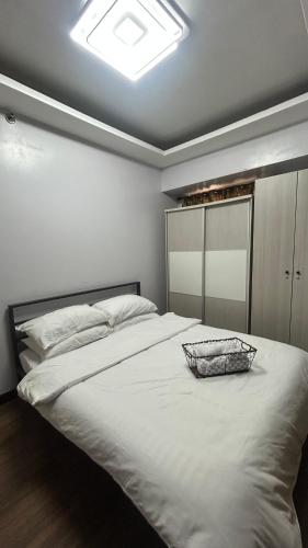 a large white bed with a bowl on top of it at Condo Unit at La Verti Residences in Manila