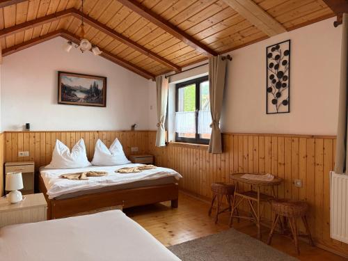 a bedroom with a bed and a table and a window at Apartmán Lukáš in Ždiar