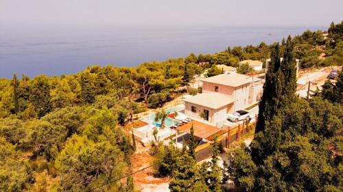 an aerial view of a house on a hill next to the water at Limestone House in Athani