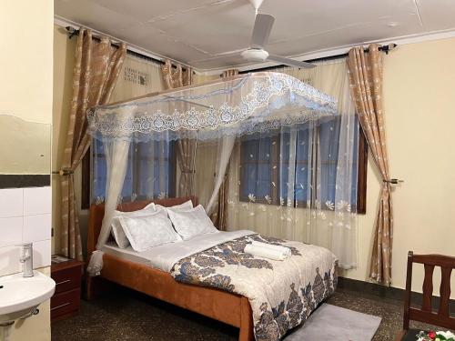 a bedroom with a canopy bed and a sink at Safari Resot Star One in Moshi
