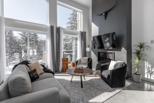 a living room with a couch and a table at Luxurious Villa Tremblant 4 Bdrs W Hot Tub B85 in Mont-Tremblant