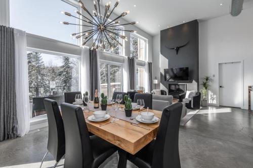 a dining room with a wooden table and chairs at Luxurious Villa Tremblant 4 Bdrs W Hot Tub B85 in Mont-Tremblant