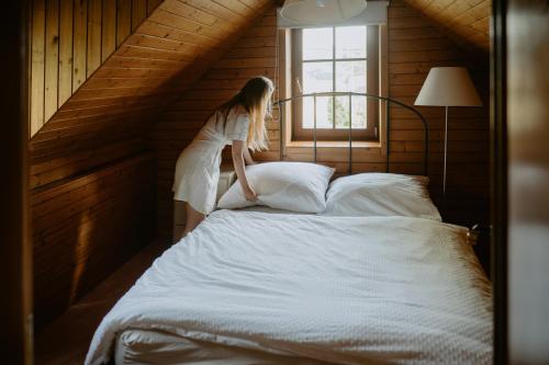 a woman sitting on top of a bed at Komora Lužná in Lužná