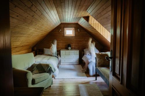 a attic room with a bed and a staircase at Komora Lužná in Lužná