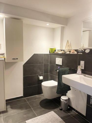 a bathroom with a white toilet and a sink at Ferienwohnung Lahntalblick in Weilburg