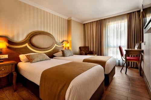 a hotel room with two beds and a desk at The Central Hotel in Istanbul