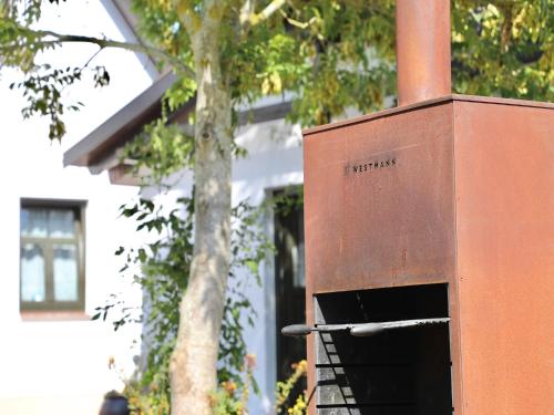 a box sitting next to a tree in front of a building at Großes Landhaus mit Swimmingpool in Dargun in Barlin