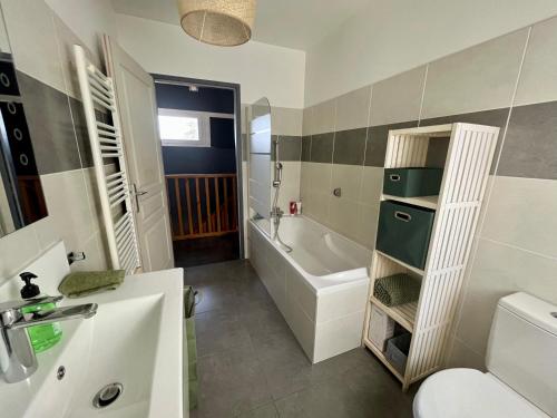a bathroom with a tub and a toilet and a sink at Maison Lili 2 chambres in Conca