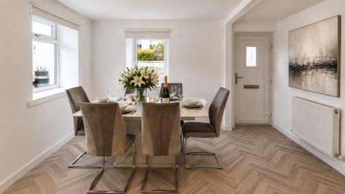 a dining room with a table and chairs at Modern Central 3 Bedroom House in Stranraer