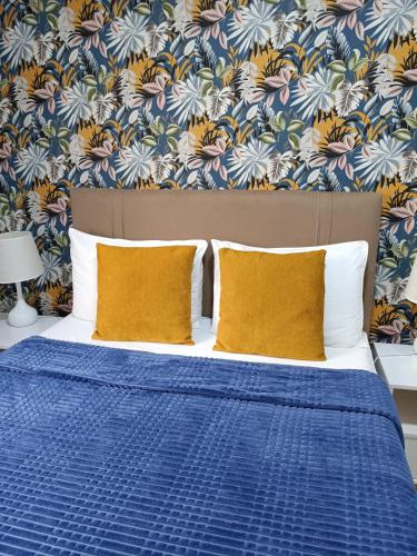 a bed with blue sheets and yellow pillows in a bedroom at Apart Atalaia ar cond 2 qtos in Aracaju