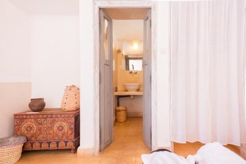 a hallway with a bathroom with a sink and a mirror at Maison d'Hôtes Irocha in Tisseldeï