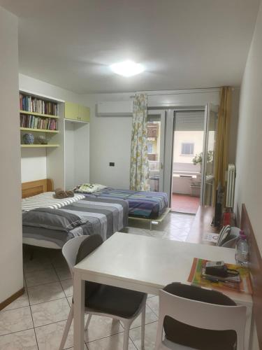 a room with two beds and a table and chairs at LeRose in Cadine