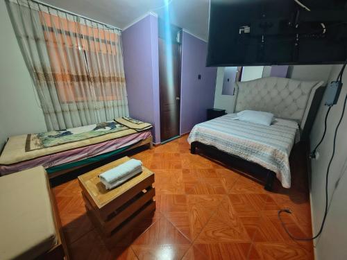a small bedroom with a bed and a table at APART TOSCANO Suites in Huancayo