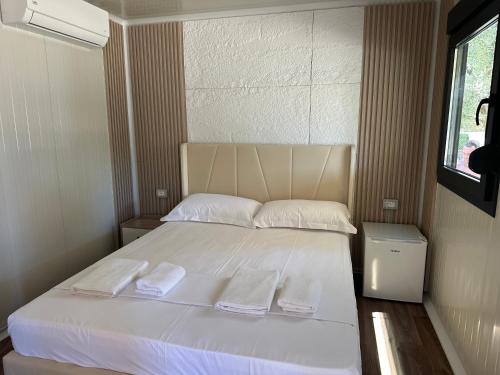 a bedroom with a bed with two towels on it at Miarla Rooms in Borsh