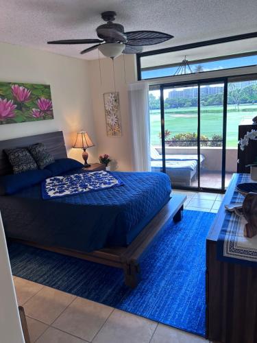a bedroom with a bed with a blue comforter at Kaanapali Royal C102 in Lahaina