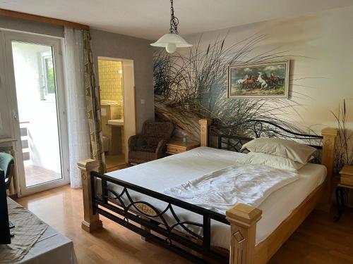 a bedroom with a bed with a painting on the wall at Pension Klaus in Bad Salzschlirf