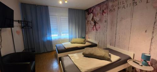 a small room with two beds and a window at Ferienwohnung FeLuMi in Wadgassen