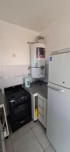 a small kitchen with a stove and a refrigerator at Apartamento Monte Grande Ameghino in Monte Grande