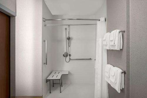 a bathroom with a shower with a bench in it at Holiday Inn Express & Suites Salem North - Keizer by IHG in Keizer