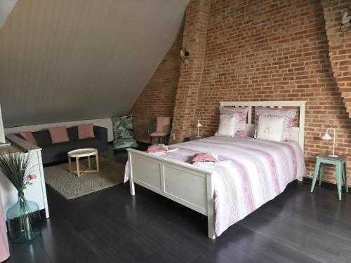 a bedroom with a bed and a brick wall at All Together in Rupelmonde