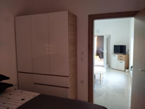 a bedroom with a large white cabinet and a room at Apartman Ema in Bihać
