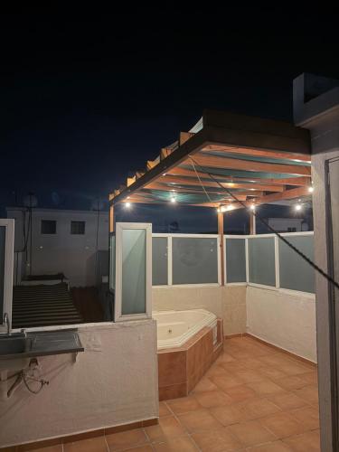 a bath tub on a balcony at night at Casa privada, alberca, jacuzzi y asador Teques in Jojutla