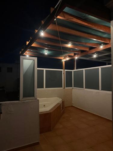 a large room with a bath tub and lights on the ceiling at Casa privada, alberca, jacuzzi y asador Teques in Jojutla