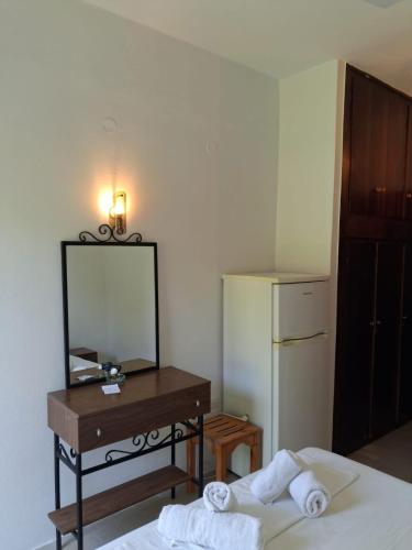 a bedroom with a mirror and a table with towels at Ellia Mirtiotissa Rooms in Glyfada