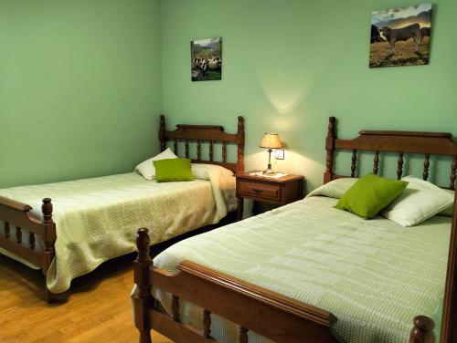 two beds in a room with green walls at Casa Rural Mikelenea in Lecároz