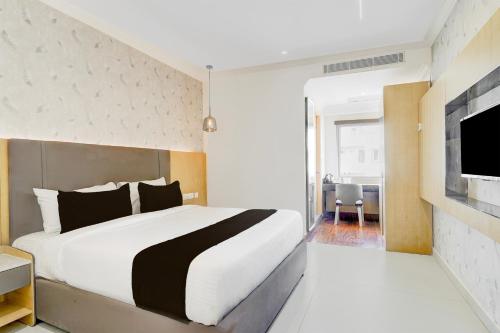 a bedroom with a large bed and a flat screen tv at Townhouse Oak AECS Layout Brookfield in Bangalore
