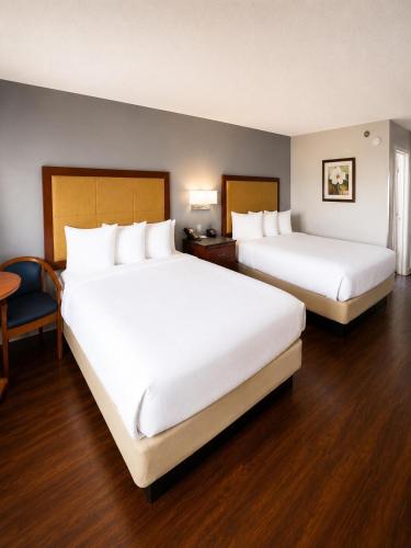two beds in a hotel room with two bedsskirts at Evergreen Inn in Branson