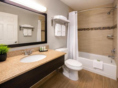 a bathroom with a sink and a toilet and a tub at Evergreen Inn in Branson