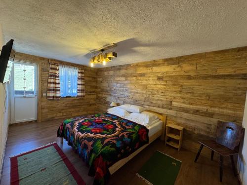 a bedroom with a bed and a wooden wall at Casa Teodora in Albac
