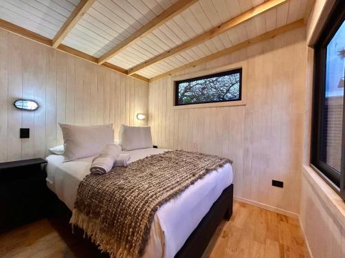 a bedroom with a bed in a room with a window at Yagan house in Puerto Natales
