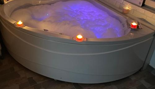 a bathtub with lights and candles in it at SPA apartman in Kragujevac